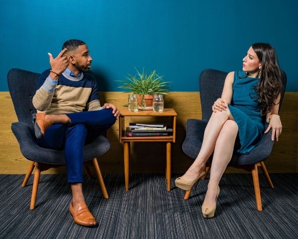 image of two person sitting on chairs and talking about In-person communication